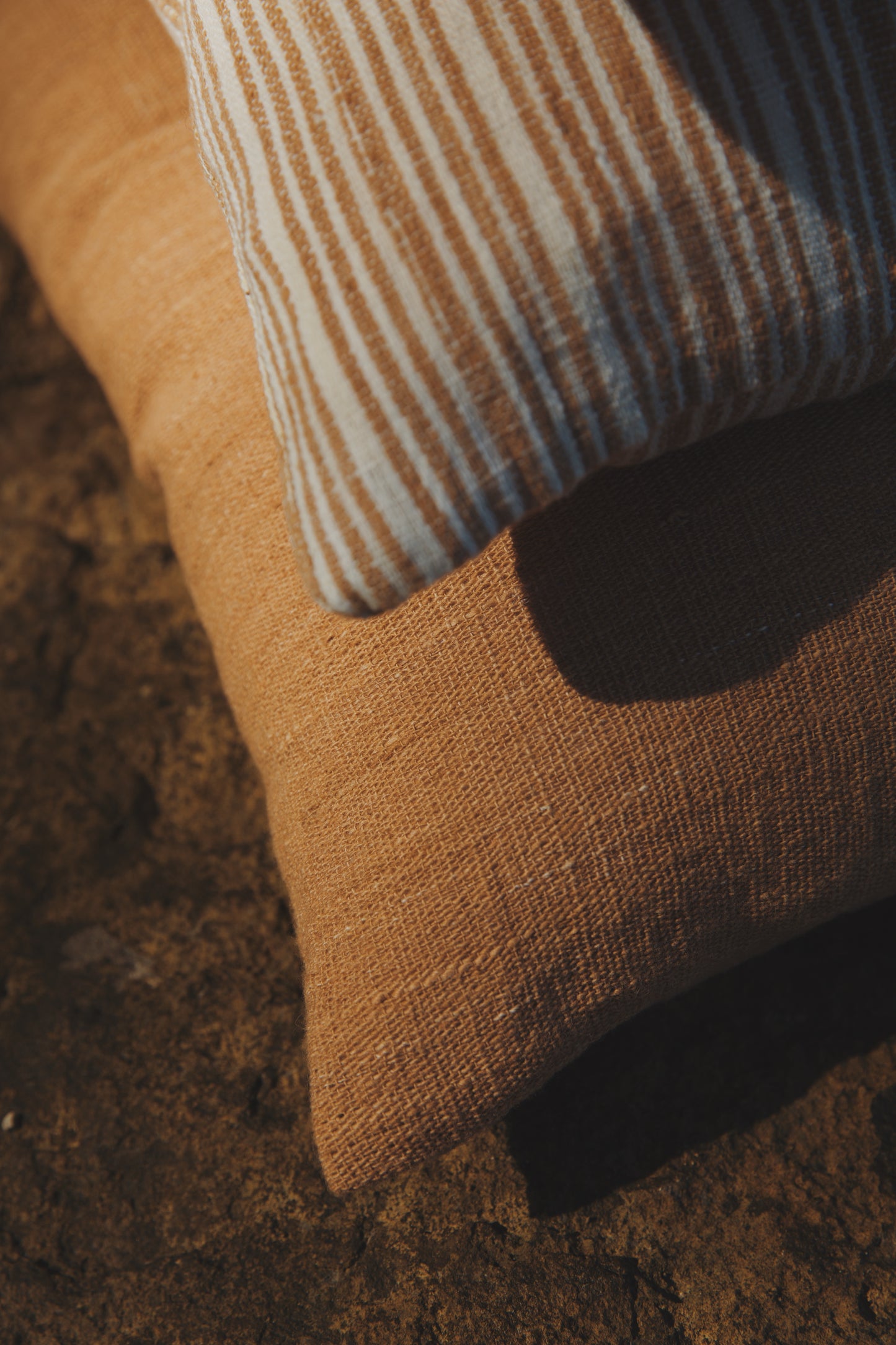Close-up of a brown textured surface with a striped pillow