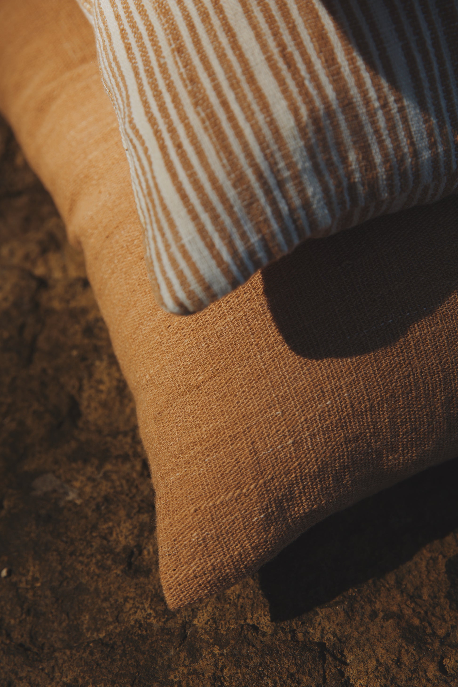 Close-up of a brown textured surface with a striped pillow