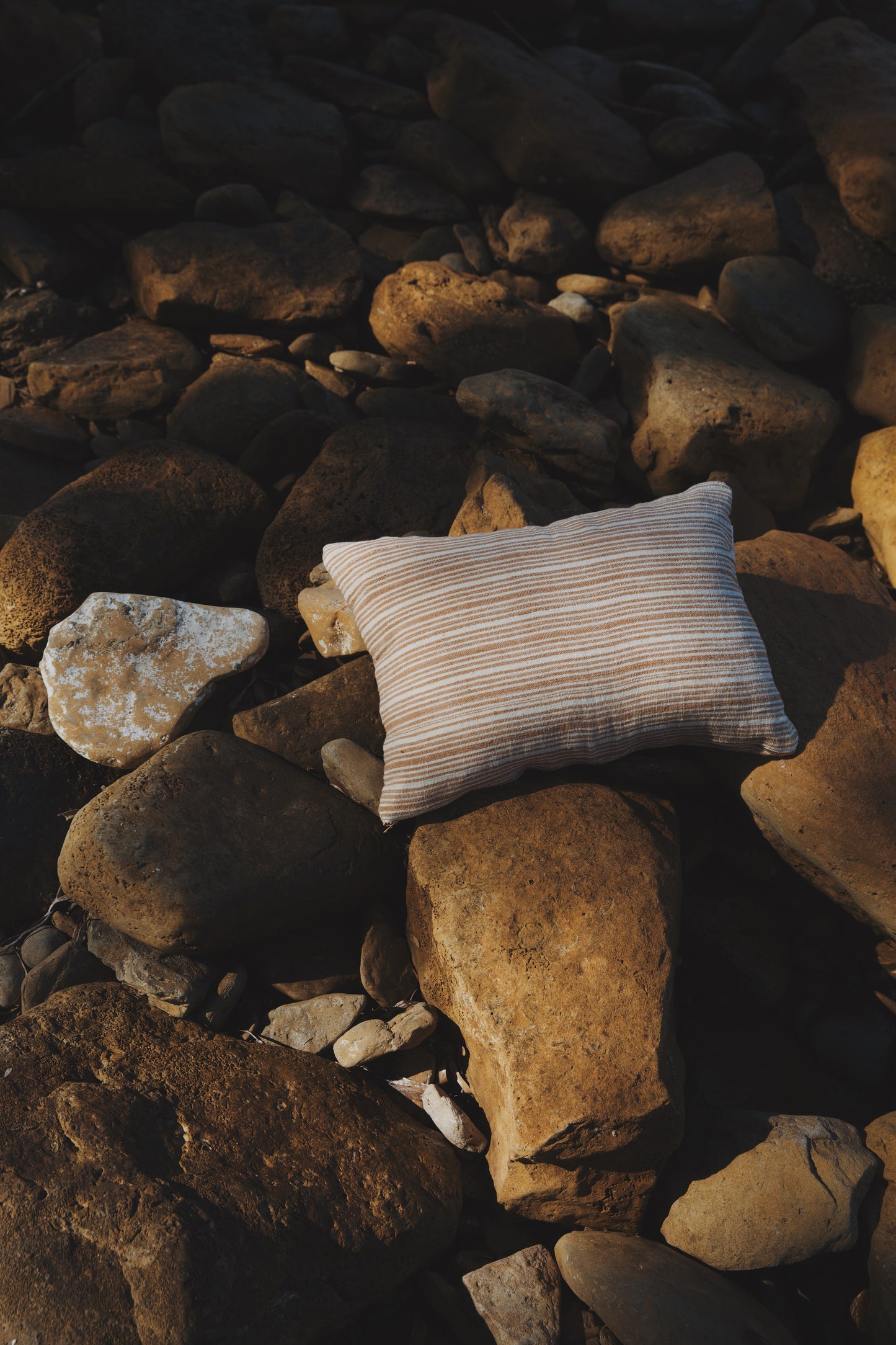 Striped pillow on a pile of rocks
