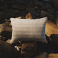 Striped pillow on a rocky surface near water