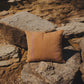Brown pillow on a stone wall