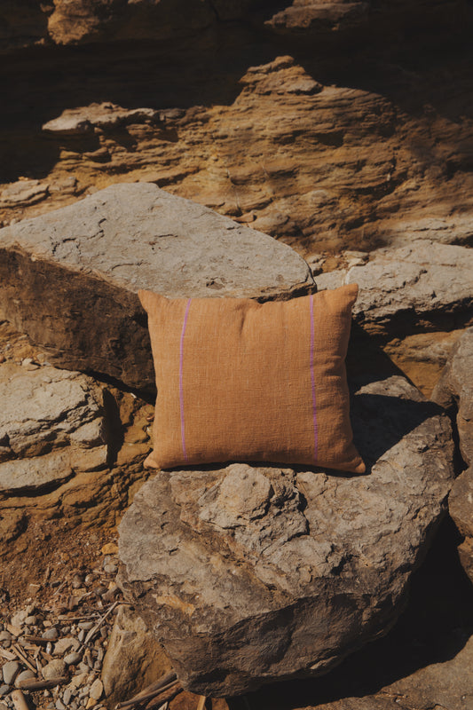 Brown pillow on a stone wall