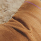 Close-up of brown fabric and line of tixinda with a blurred natural background